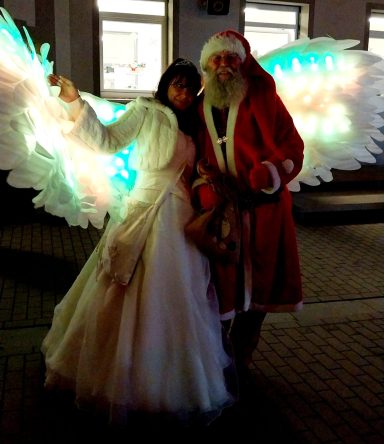 Engel in Zschortau Frau mit leuchtenden Engeln und Weihnachtsmann in festlicher Kleidung.